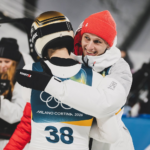 Kacper Tomasiak przy pomocy Pawła Wąska z kolejnym medalem Zimowych Igrzysk Olimpijskich.